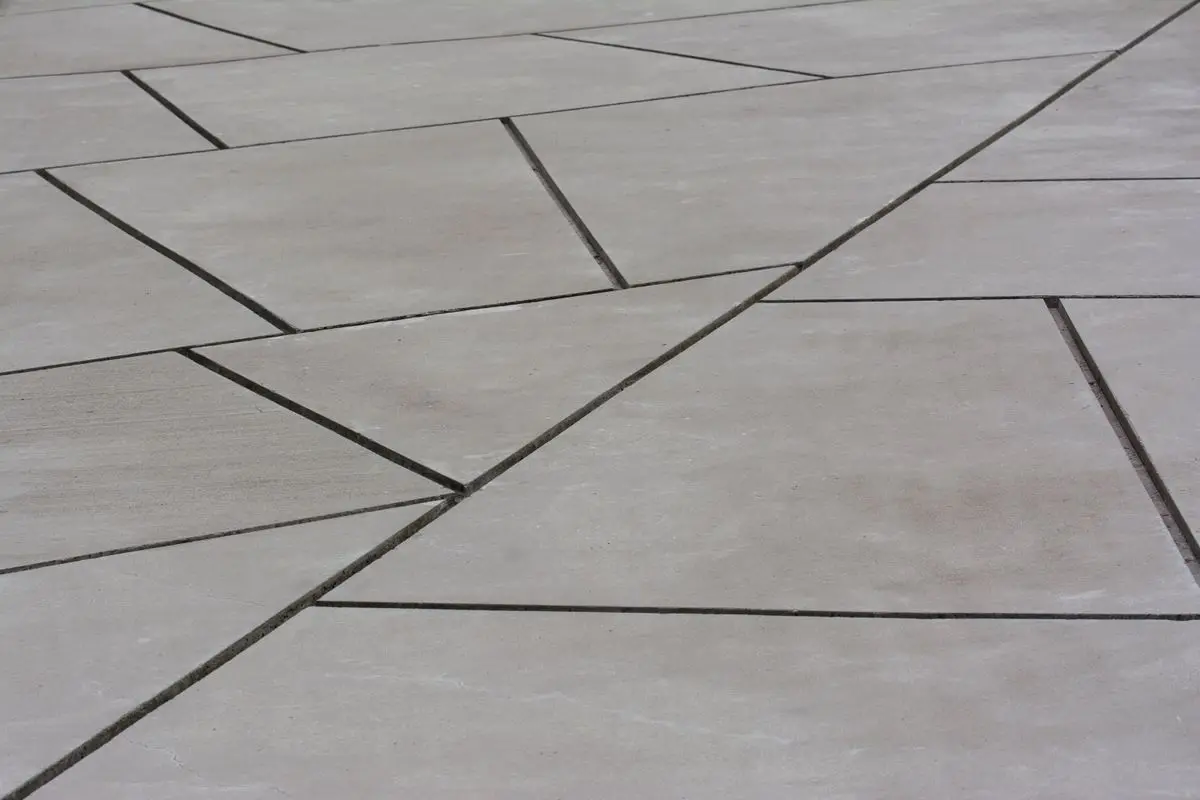Pale concrete panels with crisp saw-cut joints in a geometric layout